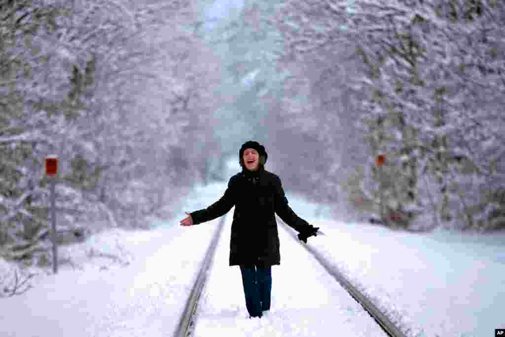 Ellen Werner enjoys the snow-covered landscape following an early spring snowstorm that dumped several inches of heavy, wet snow, in Freeport, Maine.