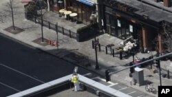 An investigator inspects the area near a surveillance camera on the roof of the Lord & Taylor store, which, an official said, is crucial in the investigation of the explosions near the Boston Marathon finish line, April 18, 2013, in Boston. 