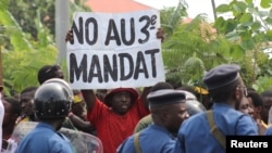 Seorang pengunjuk rasa di Bujumbura, mengangkat kertas berisikan protes menentang keputusan partai yang berkuasa, CNDD-FDD yang memperbolehkan Presiden Pierre Nkurunziza mencalonkan diri menjadi presiden untuk masa jabatan ketiga (4/5).