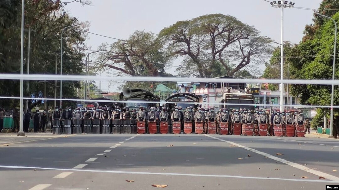 Polisi anti huru hara berjaga saat pengunjuk rasa melakukan unjuk rasa menentang kudeta militer di kota utara Myitkyina, ibu kota negara bagian Kachin, Myanmar, 20 Februari 2021. (Foto: via Reuters)