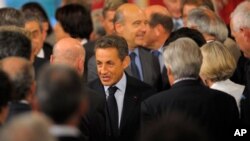 ປະທານາທິບໍດີຝຣັ່ງ ທ່ານ Nicolas Sarkozy (ກາງ) ຕິດຕາມໂດຍລັດຖະມົນຕີການຕ່າງປະເທດ ທ່ານ Alain Juppe ພວມອອກມາຈາກກອງປະຊຸມປະຈຳປີຂອງພວກເອກອັກຄະລັດຖະທູດຝຣັ່ງ ທີ່ທຳນຽບ Elysee ໃນກຸງປາຣີ (31 ສິງຫາ 2011)