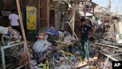 Civilians gather at the scene of a suicide car bombing at a busy market in Khan Bani Saad in the Diyala province, about 30 kilometers (20 miles) northeast of Baghdad, Iraq, July 18, 2015. 