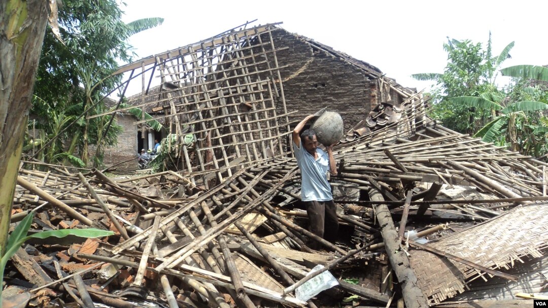 Korban angin ribut di kabupaten Sukoharjo, Jawa Tengah, di depan rumahnya yang hancur. (VOA/Yudha Satriawan)