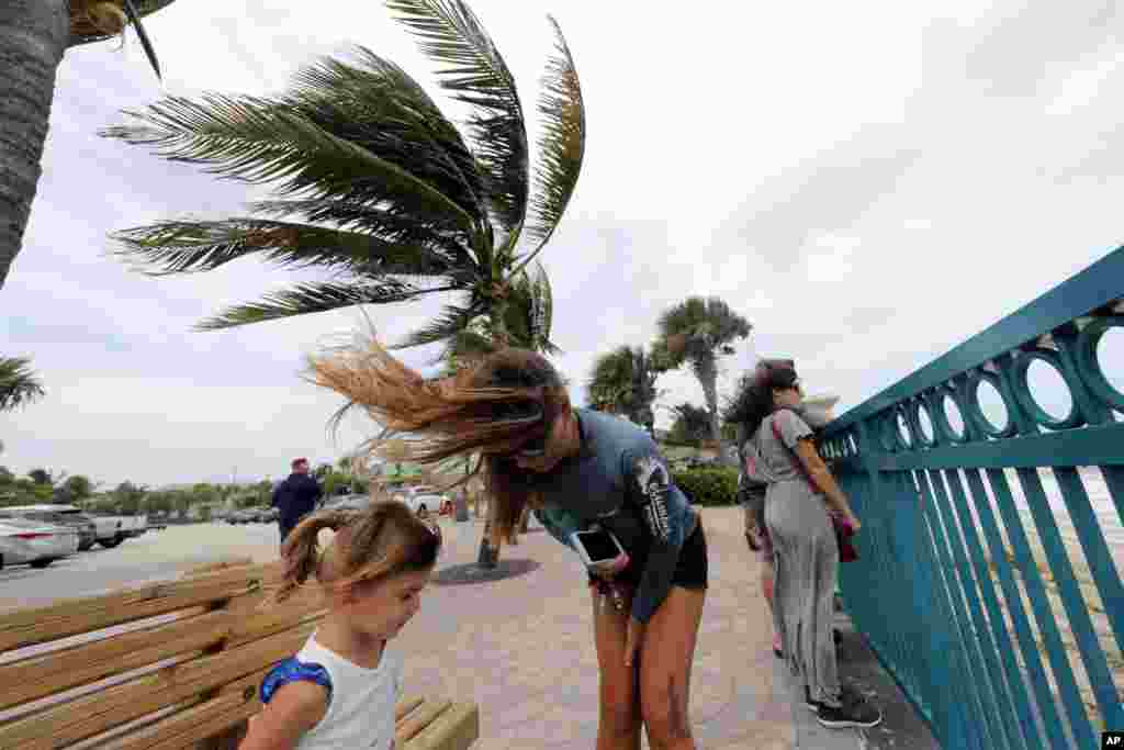 El Centro Nacional de Huracanes (NHC) informó que aunque el debilitamiento gradual es previsible, se espera que Dorian siga siendo un poderoso huracán durante los próximos días. En la foto, una mujer y su hija junto a otras personas en el malecón de Vero Beach, en Florida, el 2 de septiembre de 2019.&nbsp; AP/Gerald Herbert.