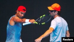 Rafael Nadal berbincang dengan pelatih baru, Carlos Moya, dalam sesi latihan menjelang turnamen Australia Terbuka, di Melbourne Park, Australia, 10 Januari 2018.