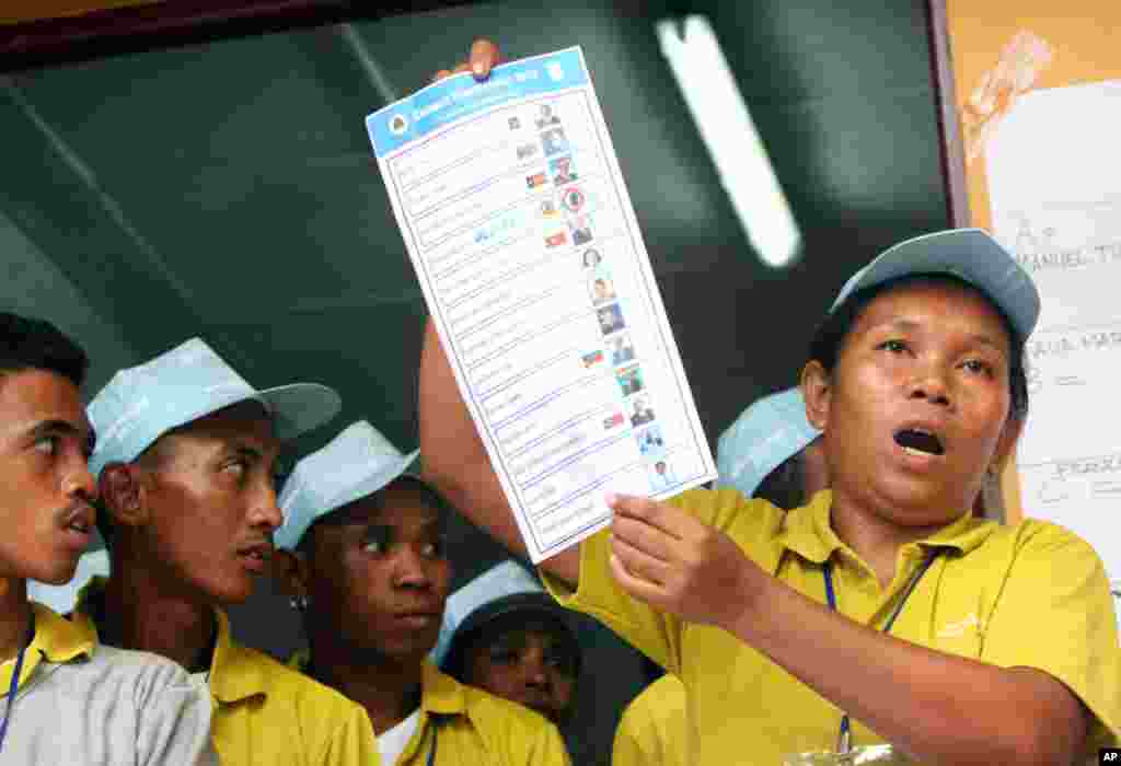 An election commission volunteer shows a ballot paper during ballot counting at a polling station in Dili, East Timor, Saturday, March 17, 2012. (AP)