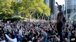 A group of protesters take a knee while marching in lower Manhattan, June 6, 2020, in New York