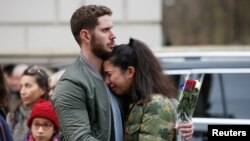 People react as they observe a minute's silence in memory of the victims of the Paris shootings, at the French Embassy in London, Britain November 16, 2015. 