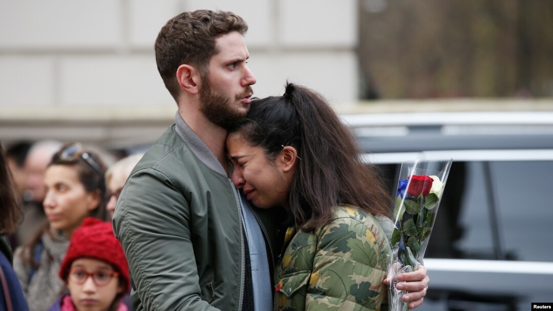 People react as they observe a minute's silence in memory of the victims of the Paris shootings, at the French Embassy in London, Britain November 16, 2015. 