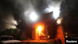FILE - A U.S. diplomatic compound is seen in flames after an attack by an armed group, in Benghazi, Libya, Sept.11, 2012.