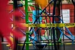 FILE - A caution tape is put up around the playground at Public School 33 following the outbreak of the coronavirus disease (COVID-19) in the Manhattan borough of New York City, New York, Sept. 27, 2020.