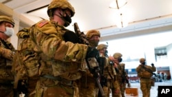 Troops stand in formation inside the visitors center to reinforce security at the Capitol in Washington, Jan. 13, 2021. 