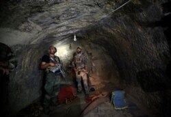 FILE - Afghan Special Forces inspect a cave used by suspected Islamic State militants in the Achin district of the province of Nangarhar, Afghanistan, April 23, 2017. The U.S. dropped a Massive Ordnance Air Blast on the cave and tunnel system.