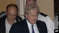 British Prime Minister Boris Johnson and his advisor Dominic Cummings, left, leave 10 Downing Street in London to go to the Houses of Parliament, Oct. 28, 2019.