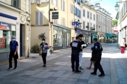 Municipal police officers check documents as they patrol in a street of Sceaux, south of Paris, France, during nationwide confinement measures to counter the Covid-19, April 8, 2020.