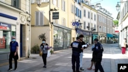 Municipal police officers check documents as they patrol in a street of Sceaux, south of Paris, France, during nationwide confinement measures to counter the Covid-19, April 8, 2020.