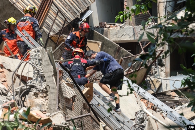 Esta fotografía tomada por la Agencia Central de Noticias de Taiwán el 3 de abril de 2024 muestra a trabajadores de emergencia ayudando a un sobreviviente tras ser rescatado de un edificio dañado en la ciudad de Nuevo Taipei, después de que un gran terremoto azotara Taiwán.