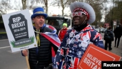 FILE - A pro-Brexit protester stands with anti-Brexit campaigner Steve Bray outside the Houses of Parliament in London, March 13, 2019. 