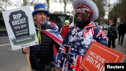 A pro-Brexit protester stands with anti-Brexit campaigner Steve Bray outside the Houses of Parliament in London, March 13, 2019. 