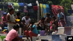 ARCHIVO - Refugiados venezolanos preparan alimentos en las afueras del campamento de Pacaraima, en el estado brasileño de Roraima. 10 de marzo de 2018.