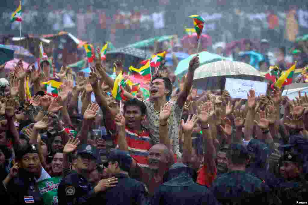 Migrant workers wave to Myanmar Foreign Minister and State Counselor Aung San Suu Kyi during a meeting at the coastal fishery center of Samut Sakhon, outside Bangkok, Thailand.