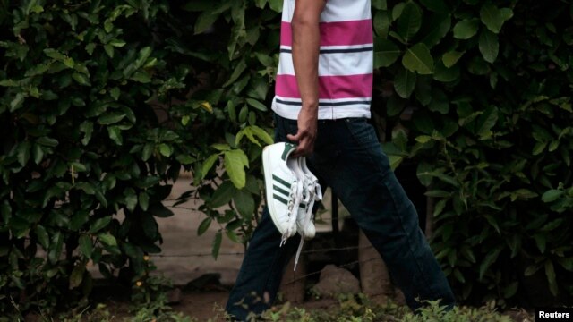 Un hombre lleva los zapatos de su hijo, luego de identificarlo como una de las siete víctimas de un tiroteo en una fiesta de graduación en Acajutla, El Salvador. Foto de Archivo. La tasa de homicidios en 2015, superó la de todos los países de Centroamérica en 16 años.