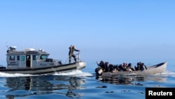 FILE — Tunisian coast guards try to stop migrants at sea during their attempt to cross to Italy, off the coast off Sfax, Tunisia April 27, 2023.