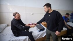 Ukrainian President Volodomyr Zelenskyy awards injured Ukrainian military personnel as he visits a hospital in Mykolaiv, Ukraine, on Oct. 20, 2023. (Ukrainian Presidential Press Service via Reuters)