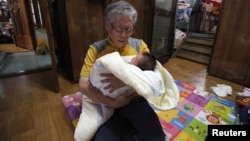 Seorang kakek menggendong bayi di gereja Joosarang di Seoul, Korea Selatan.