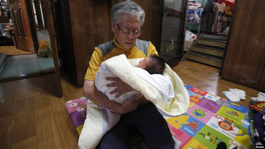 Seorang kakek menggendong bayi di gereja Joosarang di Seoul, Korea Selatan.