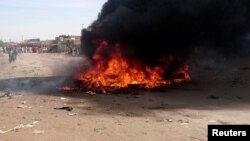 FILE - A bonfire is lit along a street during protests against price increases in Atbara, Nile River state, Sudan, Dec. 20, 2018.