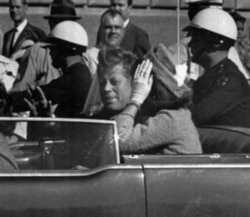 President Kennedy rides in a motorcade with his wife, Jacqueline, moments before he was shot and killed in Dallas, Texas, on November 22, 1963