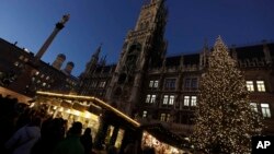 Visitors take a stroll at the Christmas market in front of the town hall at the Marienplatz square in Munich, Germany, Dec. 8, 2016. A strong police presence was felt at the square following the Berlin market attack.