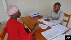 A lawyer gives legal advice to his client inside the USAID-funded Gisenyi Legal Aid Clinic in Rwanda. 