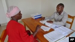 Lawyer Pascal Dusengeyeru gives legal advice to his client, Bernadine Nyiramugisha, inside the USAID-funded Gisenyi Legal Aid Clinic