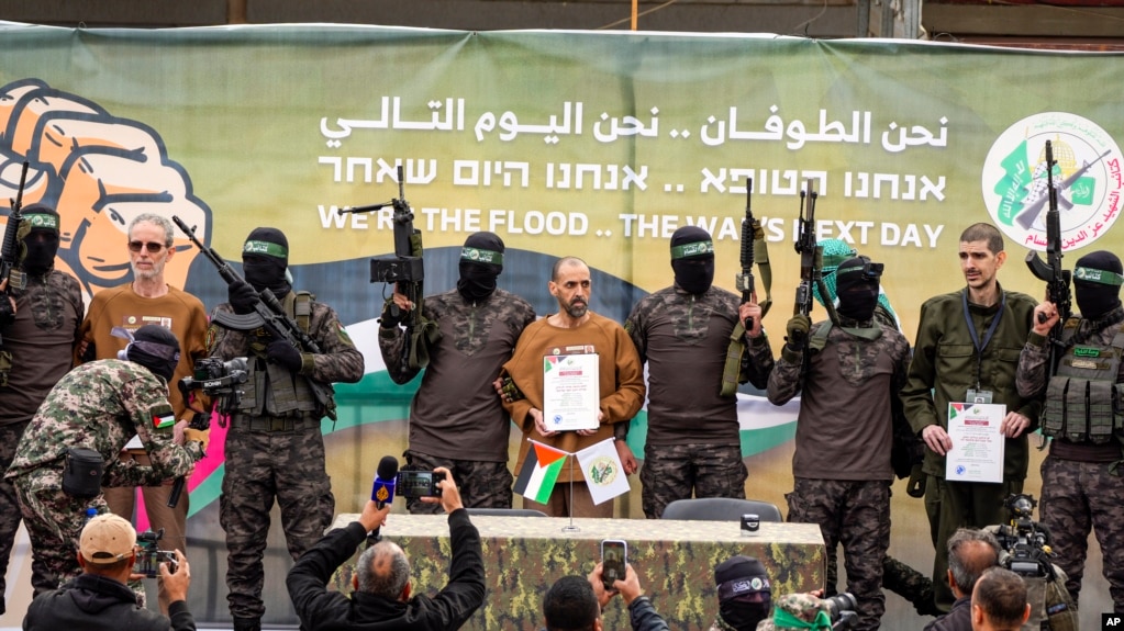 Con tin Israel bị Hamas giam giữ ở Gaza kể từ ngày 7/10/2023, từ trái sang phải, Ohad Ben Ami, Eli Sharabi và Or Levy, được các chiến binh Hamas đưa lên một sân khấu trước khi được trao trả cho Hội Chữ thập đỏ ở Deir al-Balah, Gaza, ngày 8/2/2025. (Ảnh AP/Abdel Kareem Hana)