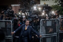 An unidentified man tries to hold back the press as Saudi investigators arrive at the Saudi Arabian Consulate in Istanbul, Turkey, amid a growing international backlash to the disappearance of journalist Jamal Khashoggi.