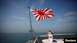 인도양에서 훈련 중인 일본 해상자위대의 헬리콥터모함 '카가'에서 자위대원이 전범기인 '욱일기'를 달고 있다. 