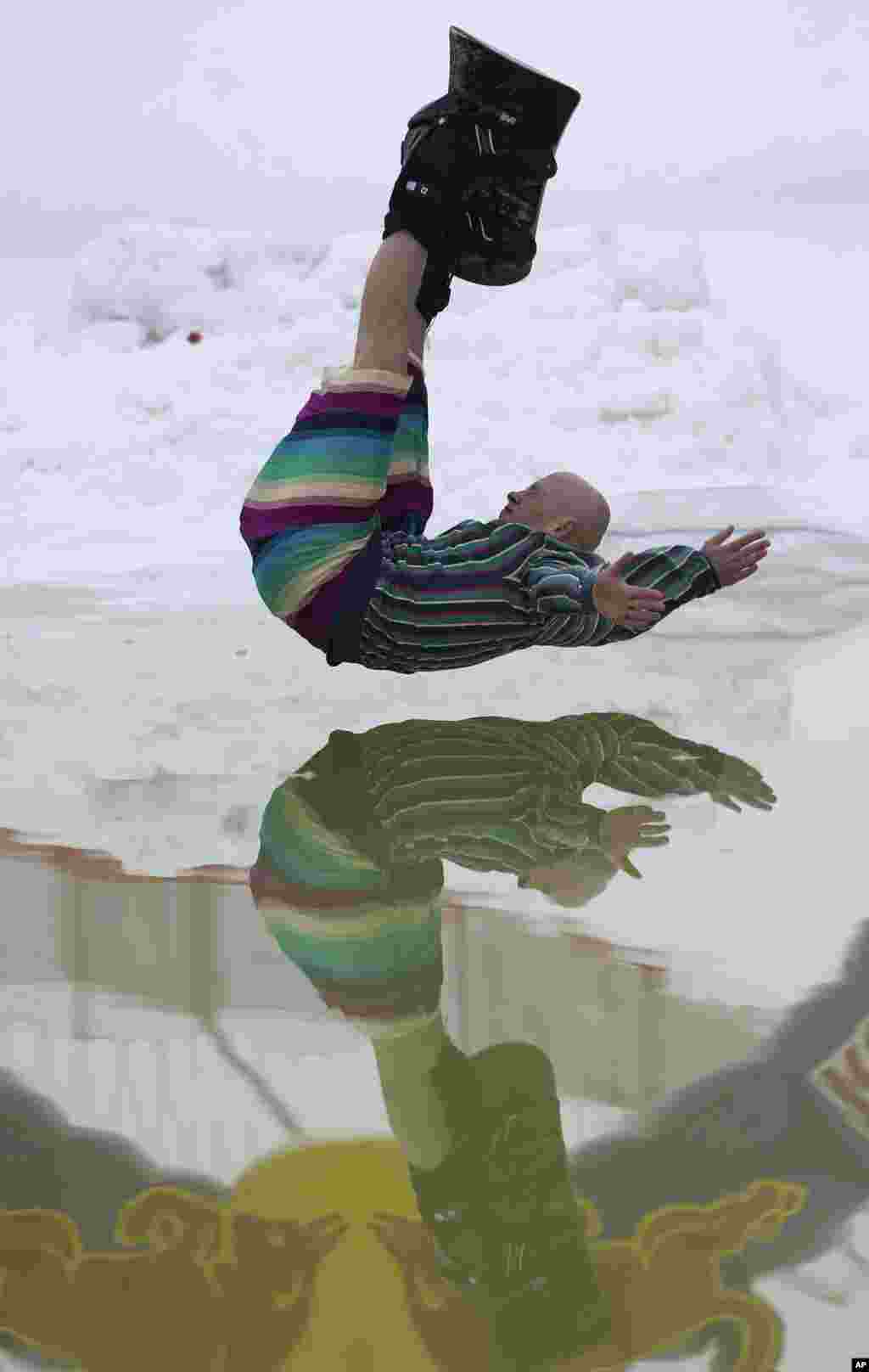 一位白俄罗斯玩滑雪板的高手参加距离白俄罗斯首都明斯克45公里的一个娱乐中心举办的庆祝冬天结束的滑稽比赛活动。