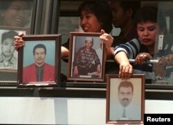 Beberapa orang memasang foto-foto kerabat yang hiland dalam demonstrasi di Jakarta, 16 September 1998.
