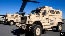 FILE - Mine-resistant, ambush-protected vehicles (MRAP), produced by Navistar, are loaded onto an airplane at Charleston Air Force Base in North Charleston, S.C.