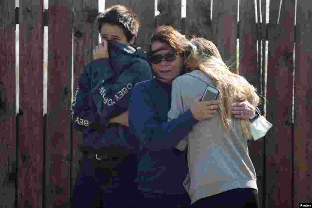 Local residents react as numerous homes burn on a hillside during a wind driven wildfire in Ventura, California, Dec. 5, 2017.