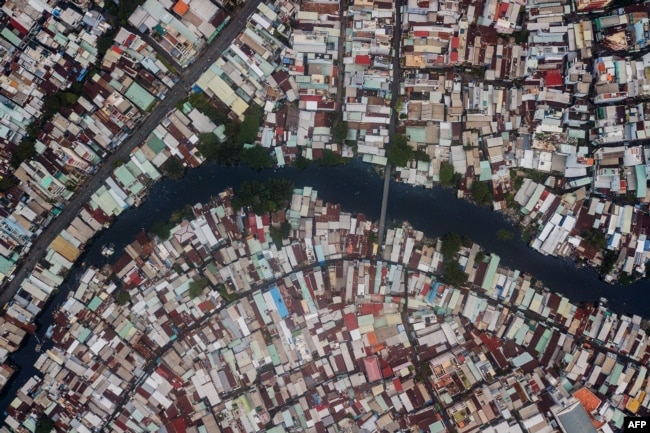 FILE - This aerial photo taken on October 19, 2018 shows houses along the Xuyen Tam canal in Ho Chi Minh City.