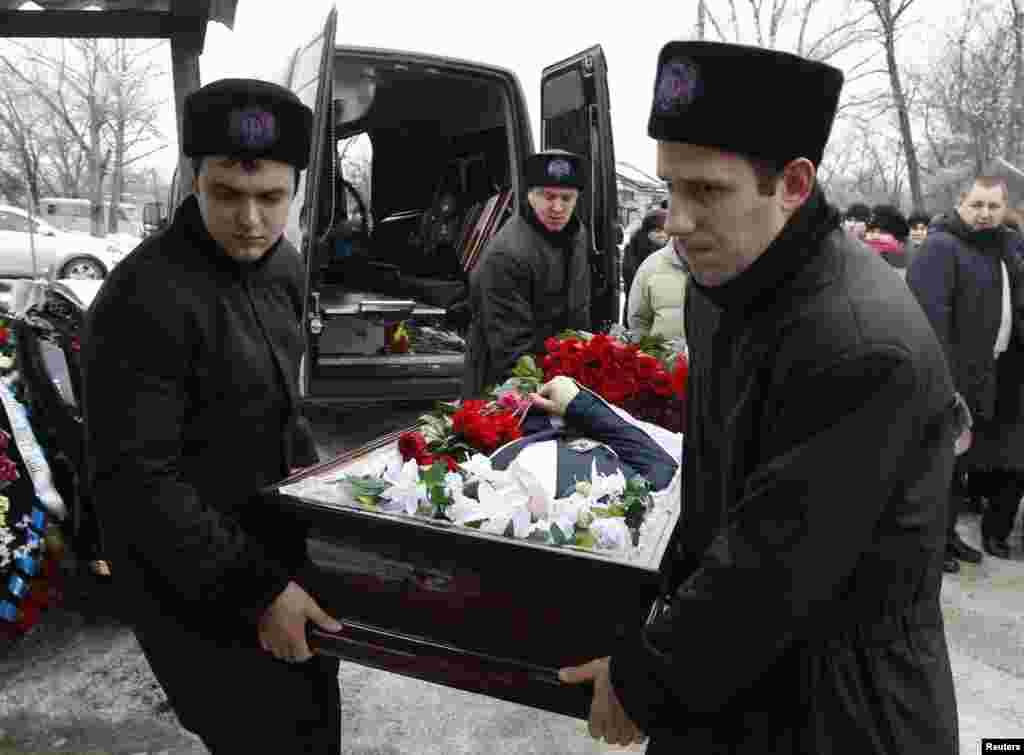 Pallbearers carry the coffin of Denis Andreev, age 24, who was killed by a suicide bomb blast in the main railway station, Volgograd, Russia, Jan. 1, 2014.