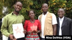 Maseray Kamara, flanked by her fellow burial team members in Freetown, holds the the Bond International Humanitarian Award, given to burial teams from across Sierra Leone for their contributions to stopping the spread of the Ebola virus, June 5, 2015.
