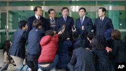 Chung Ki-sup, top center, the head of the council of South Korean companies operating in the Kaesong factory park, speaks to the media after returning from North Korea's Kaesong Industrial Complex, at the Inter-Korean Transit Office near the border villag