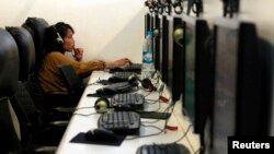 FILE - A woman surfs the web at an internet cafe in Bangkok, Sept. 29, 2010. Thailand's legislature passed a bill that would allow authorities access to personal information on people's computers without a court order. 