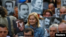 FILE - Human rights activists hold portraits of victims during a demonstration to commemorate the 1915 mass killing of Armenians in the Ottoman Empire, in central Istanbul, Turkey, Apr. 24, 2018. 