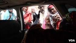 As Hajia Hawa drives around Maiduguri, displaced Nigerians come to her to ask for money and free food vouchers, Maiduguri, Nigeria, Sept. 2016. (Photo: C. Oduah)