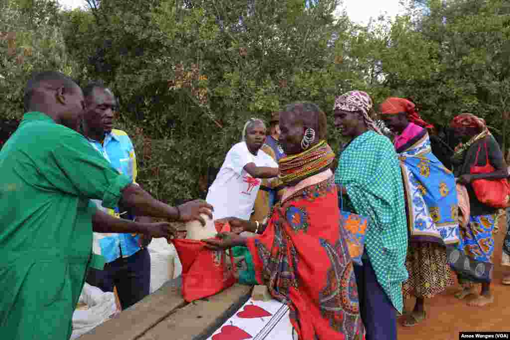 Village women collect food donations from the Laikipia Nature Conservancy in Kenya, where owner Kuki Gallmann distributes staple foods and water to help her neighbors get through the drought, March 19, 2017. (Jill Craig/VOA)